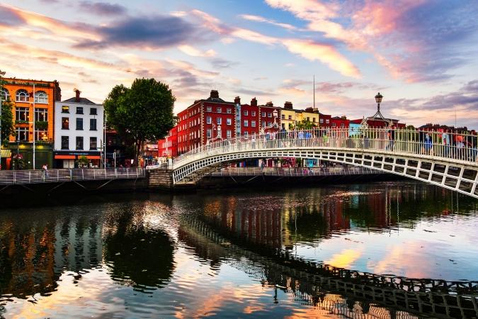 Brücke über einen Fluss mit bunter Architektur bei Sonnenuntergang