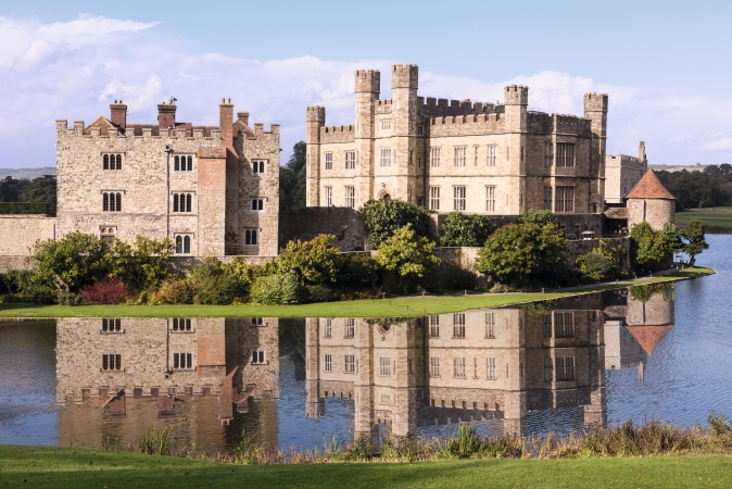 Historisches Schloss mit Wassergraben und Spiegelung im Wasser.