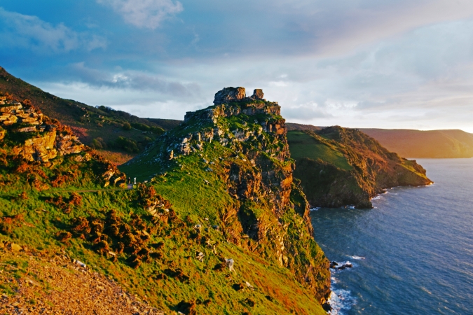 Felsige Küstenlandschaft bei Sonnenuntergang mit Blick auf das Meer.